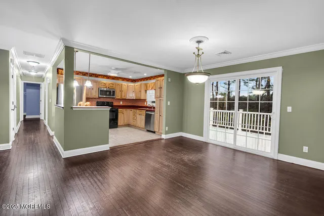 a view of a big room with wooden floor and windows