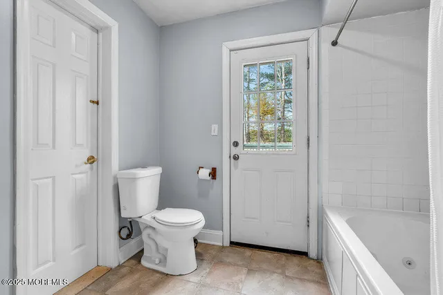 a bathroom with a toilet and a tub