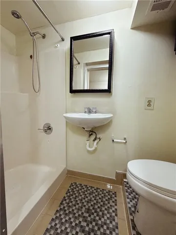 a bathroom with a sink a toilet and shower