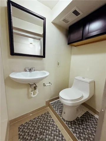 a bathroom with a sink toilet and mirror