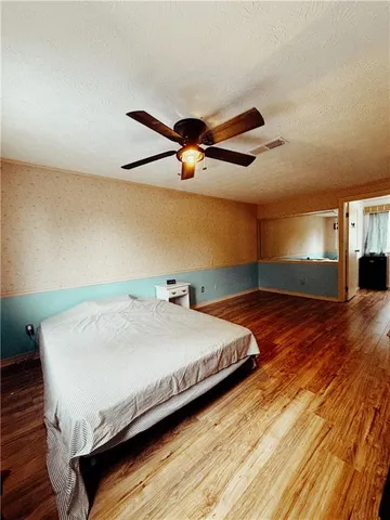 a bedroom with a bed and a ceiling fan