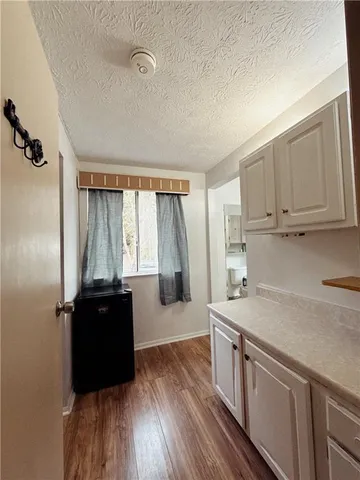 a kitchen with stainless steel appliances granite countertop a refrigerator a sink dishwasher a stove and white countertops with wooden floor