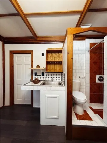 a bathroom with a sink a toilet and shower