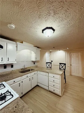 a kitchen with a sink appliances and cabinets