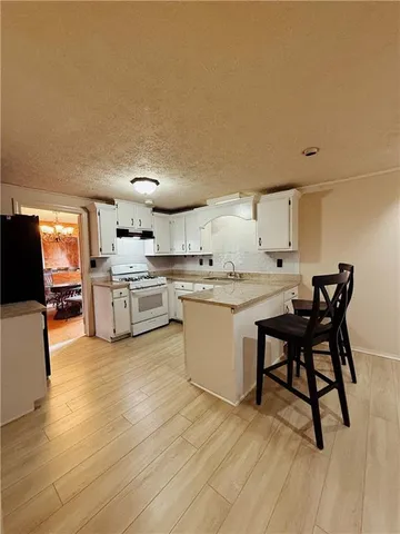 a kitchen with a table chairs microwave and cabinets