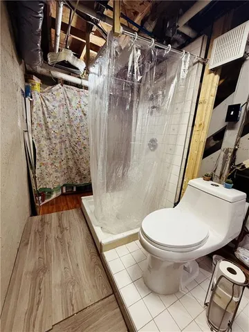 a bathroom with a toilet and a shower