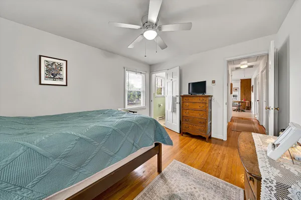 a spacious bedroom with a bed and a dresser