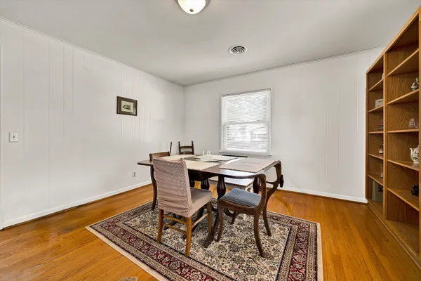 a workspace room with wooden floor and a window