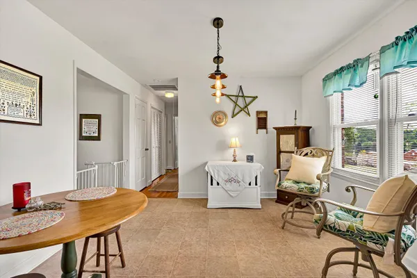a living room with furniture a dining table and a chandelier