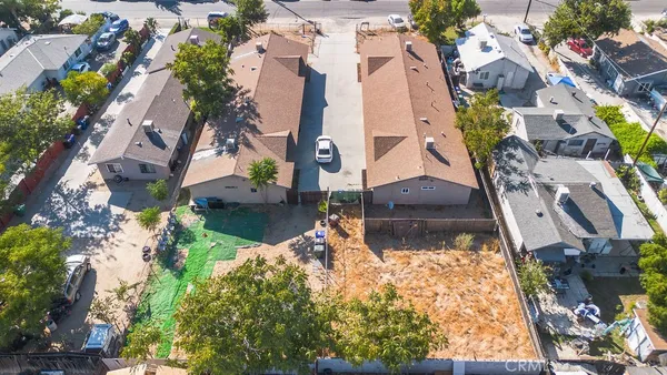 an aerial view of a house with a yard and large trees