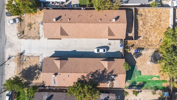 an aerial view of a house with a yard and a wooden fence