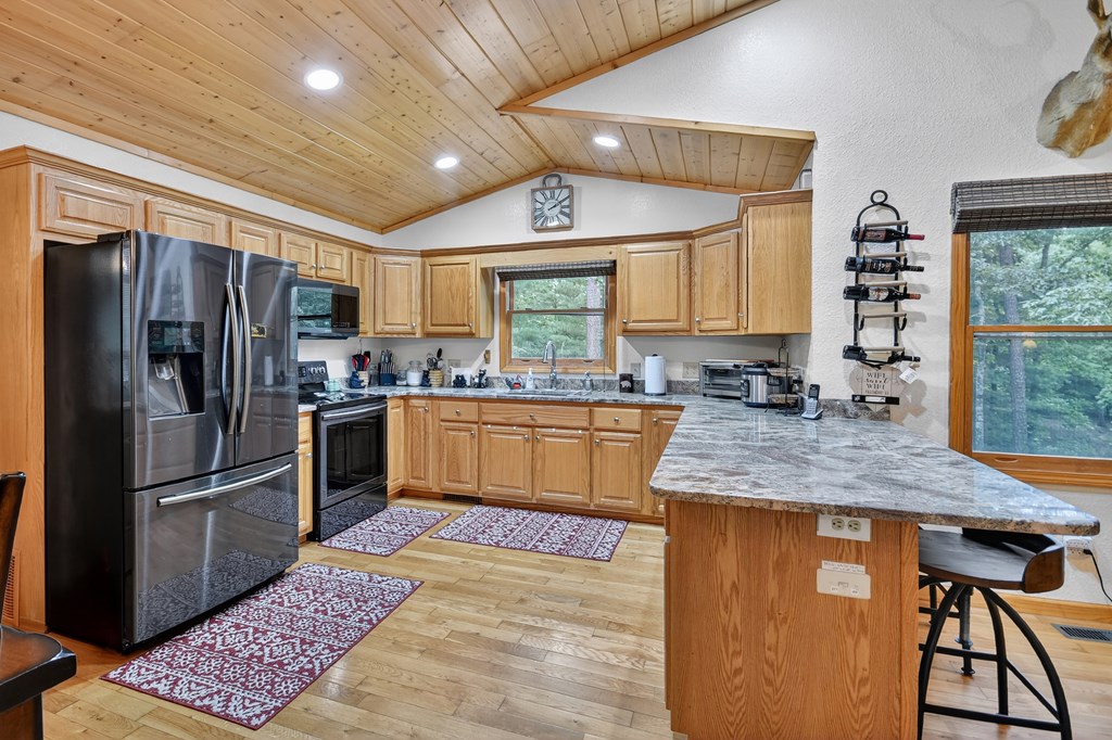 1044 Boulder Crk Road Murphy, NC 28906 - Photo 23 of 38 a kitchen with stainless steel appliances granite countertop a refrigerator a sink dishwasher a stove with wooden cabinets and floor