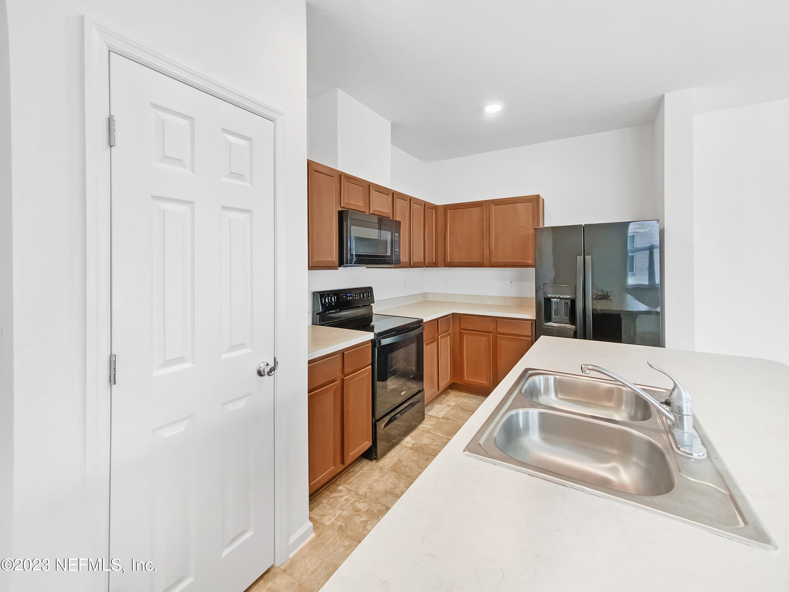 7909 Merchants Way Jacksonville, FL 32222 - Photo 11 of 19 a kitchen view with granite countertop a sink and a refrigerator
