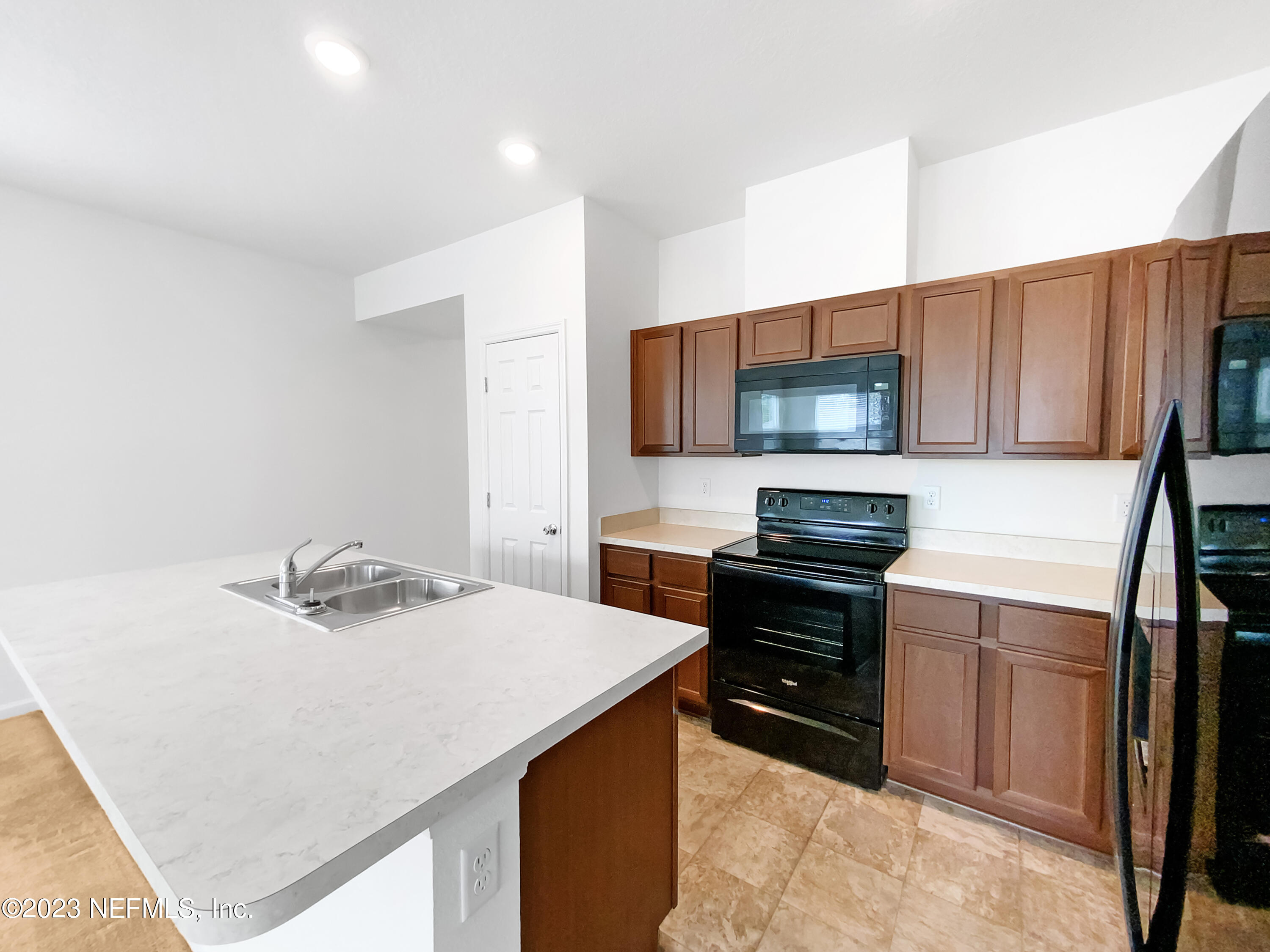 7909 Merchants Way Jacksonville, FL 32222 - Photo 13 of 19 a kitchen with a stove a microwave and wooden cabinets