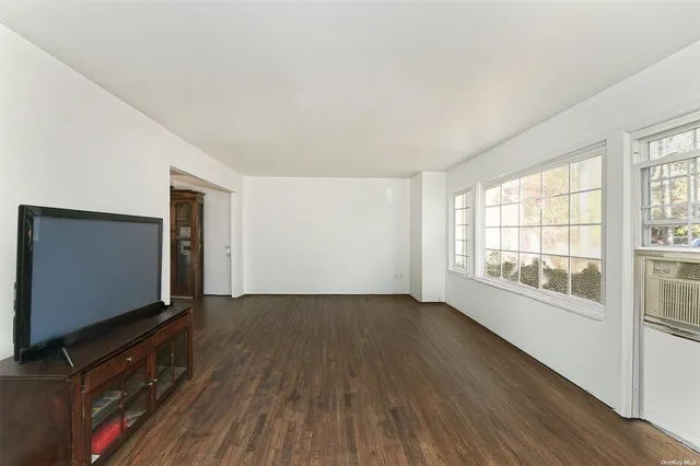 a living room with hardwood floor and flat screen tv