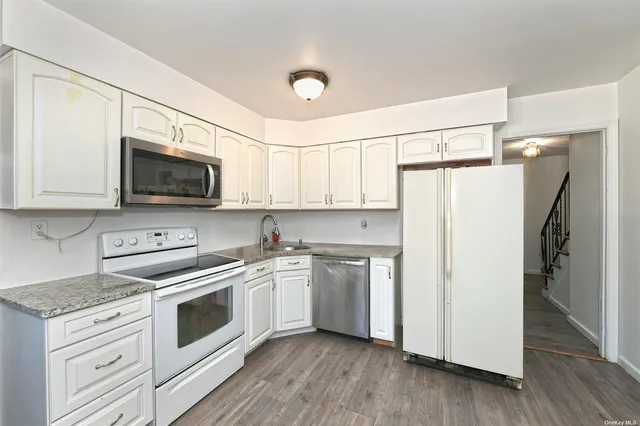 a kitchen with white cabinets and white appliances