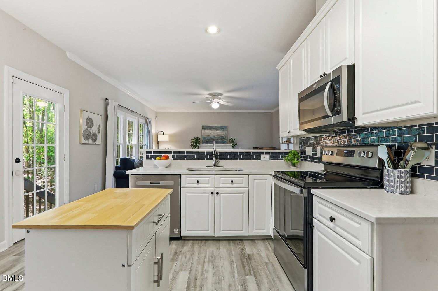 4001 Batiste Road Raleigh, NC 27613 - Photo 19 of 63 a kitchen with stainless steel appliances granite countertop a stove top oven a sink dishwasher and white cabinets with wooden floor