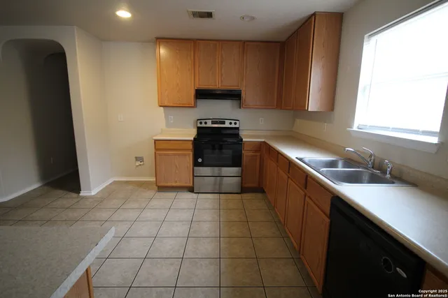 a kitchen with a sink a stove and a refrigerator
