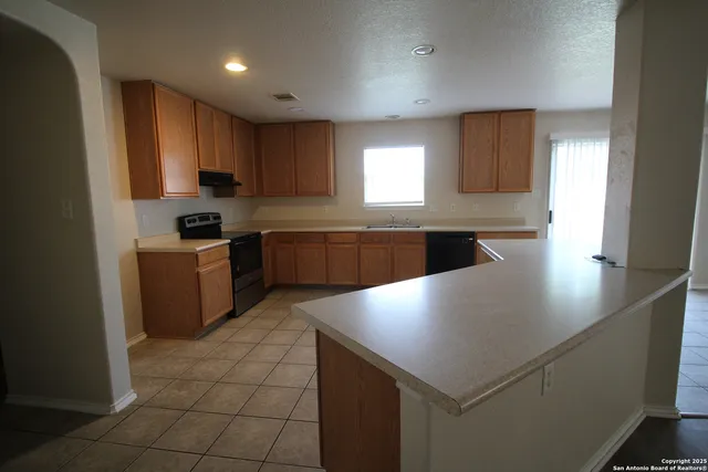 a kitchen with stainless steel appliances granite countertop a sink a stove and a refrigerator