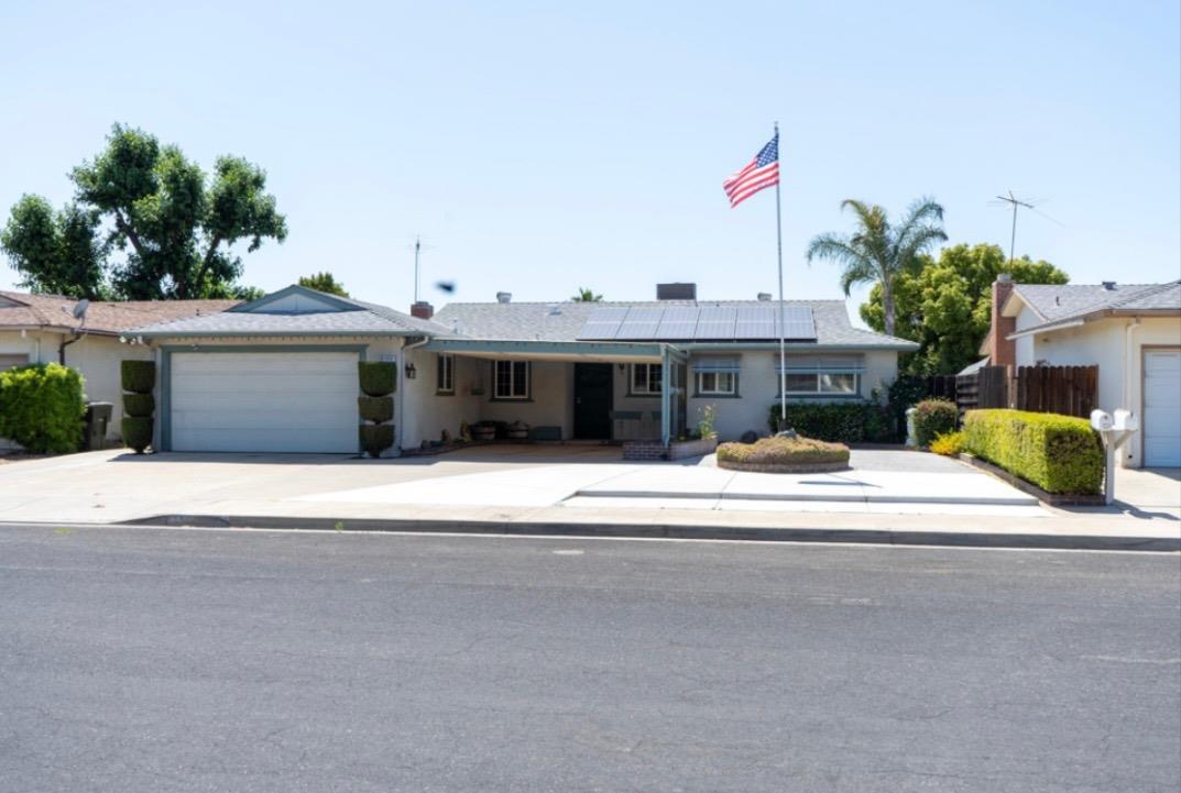 a view of a house with a yard and potted plants