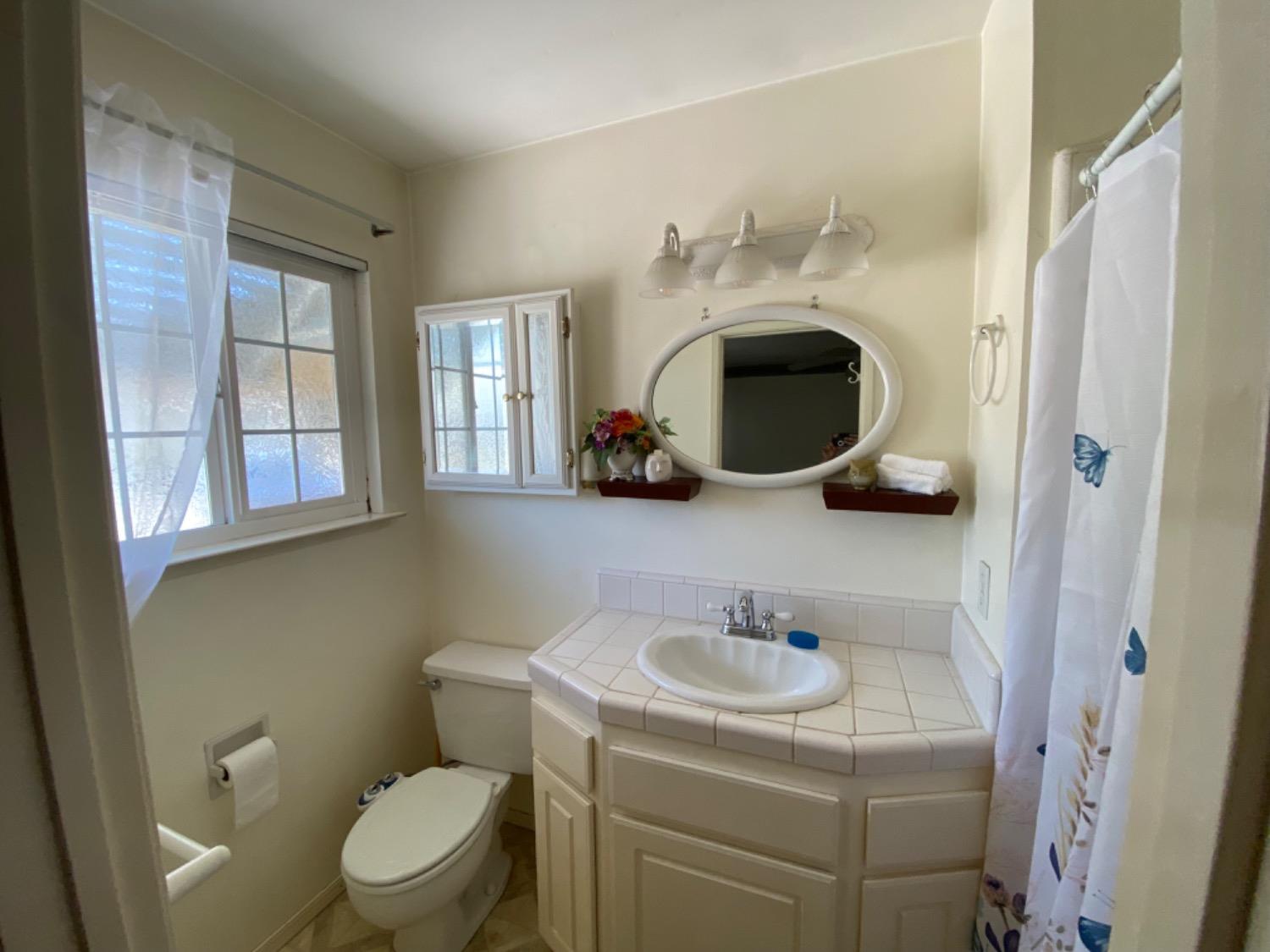 1712 Bundy Avenue Clovis, CA 93611 - Photo 6 of 9 a bathroom with a toilet sink and mirror