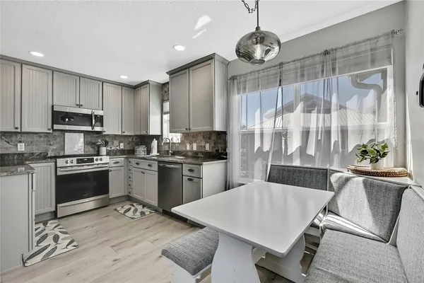 a kitchen with stainless steel appliances granite countertop a sink a stove and cabinets