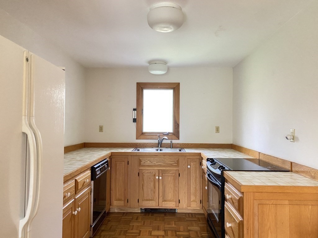 117 Rock O'Dundee Road Dartmouth, MA 02748 - Photo 13 of 24 a kitchen that has a sink a stove and a refrigerator