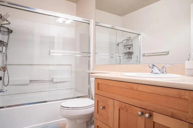 a bathroom with a sink a toilet and shower