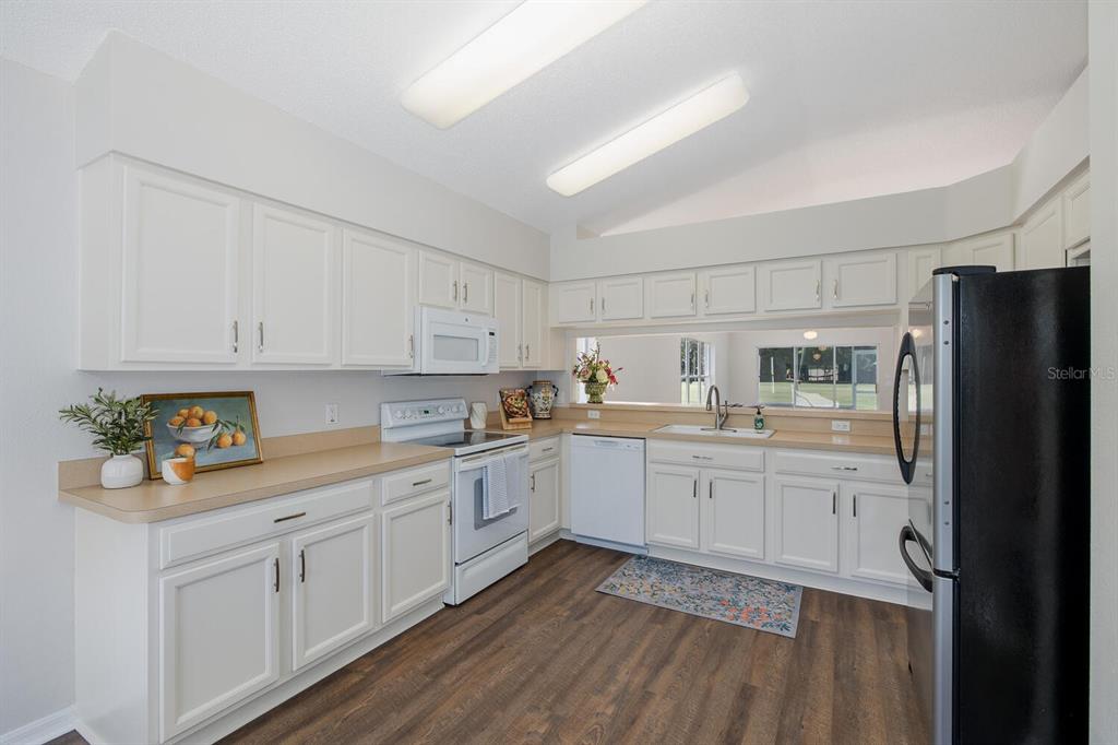 11718 Wheatfield Loop Hudson, FL 34667 - Photo 17 of 88 a kitchen with granite countertop white cabinets and refrigerator