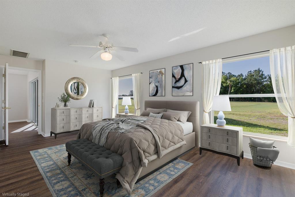 11718 Wheatfield Loop Hudson, FL 34667 - Photo 27 of 88 a bedroom with a bed a mirror and a large window with the outer view