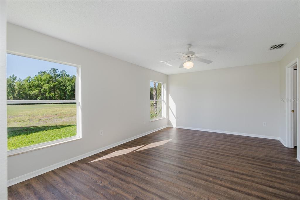 11718 Wheatfield Loop Hudson, FL 34667 - Photo 28 of 88 a view of an empty room with wooden floor and a window