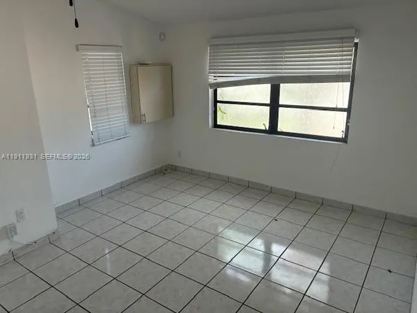 a kitchen with white cabinets a sink and a stove with wooden floor