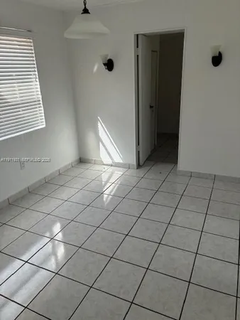 an empty room with windows and glass door