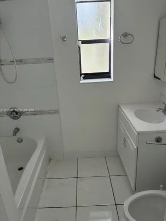 an empty room with white walls and tiles