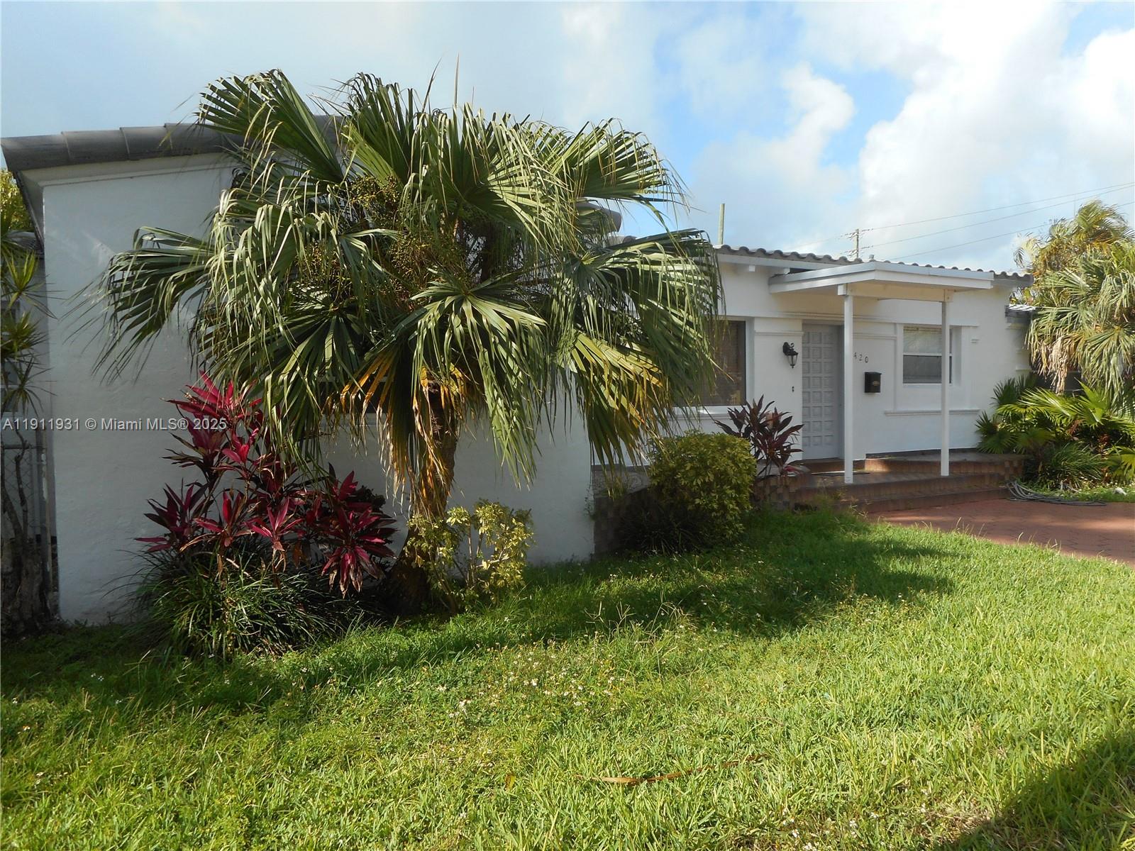 420 88th Street Surfside, FL 33154 - Photo 4 of 19 a front view of a house with a garden