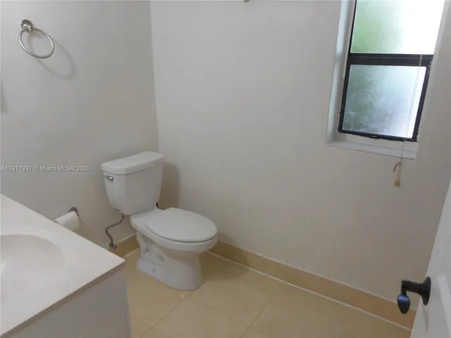 a white toilet sitting next to a white sink and vanity