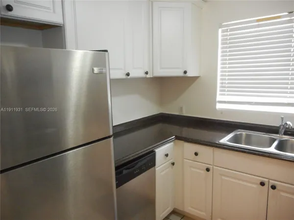 a kitchen with a refrigerator and a sink