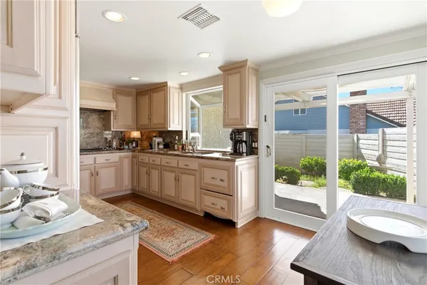 a kitchen with white cabinets and window