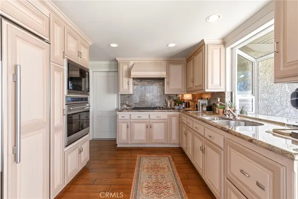 a large kitchen with stainless steel appliances granite countertop a stove a sink and a granite counter tops