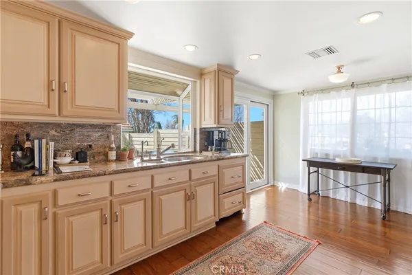 a kitchen with granite countertop white cabinets and sink
