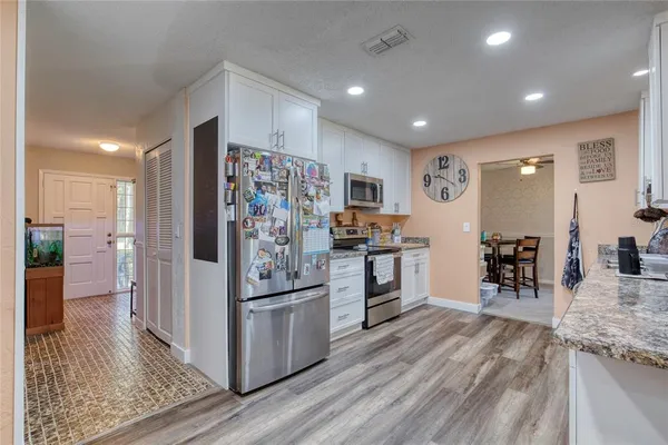 a kitchen with stainless steel appliances granite countertop a refrigerator and a stove top oven
