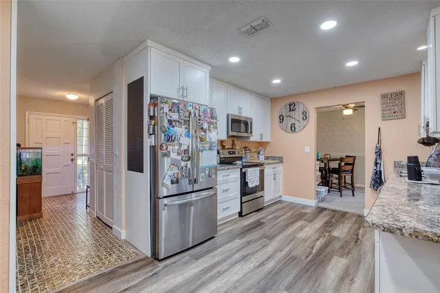 a kitchen with stainless steel appliances granite countertop a refrigerator and a stove top oven