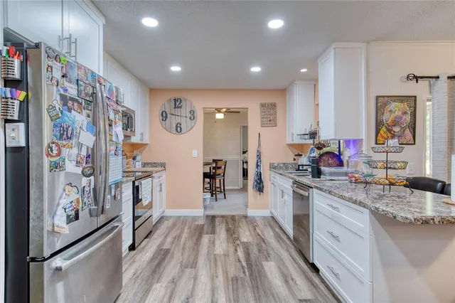 a large kitchen with stainless steel appliances a refrigerator and a sink