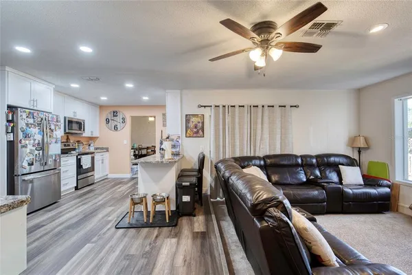 a living room with furniture and a wooden floor
