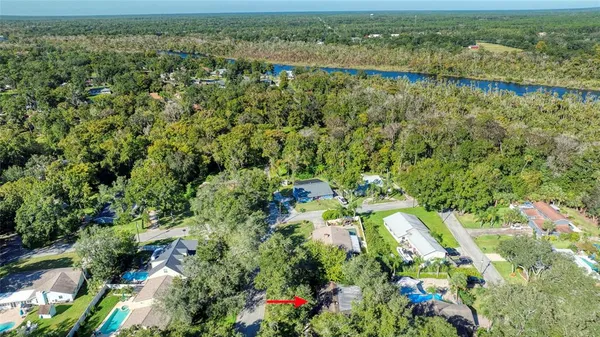 an aerial view of residential houses with outdoor space and trees