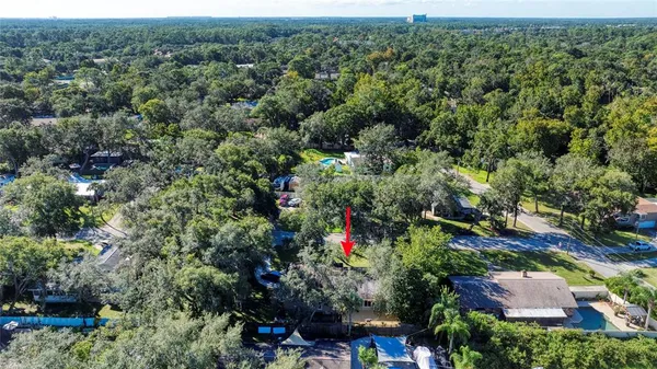 an aerial view of residential house with outdoor space and trees all around