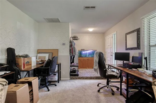 a view of a workspace with furniture and a window