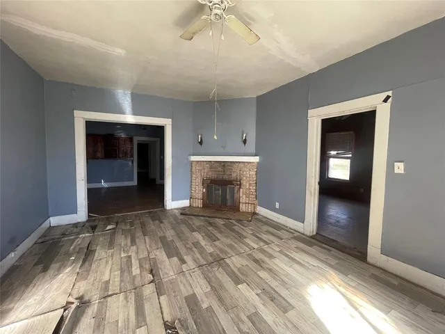 a view of an empty room with a fireplace and a window