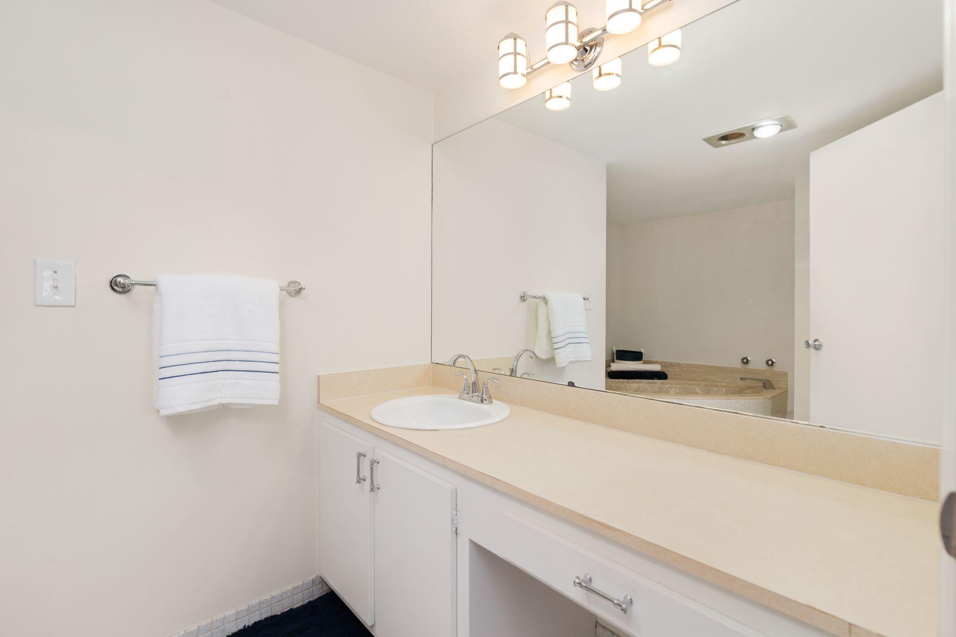 1701 South Flagler Drive, Unit 207 West Palm Beach, FL 33401 - Photo 14 of 26 a bathroom with a sink a vanity and a mirror