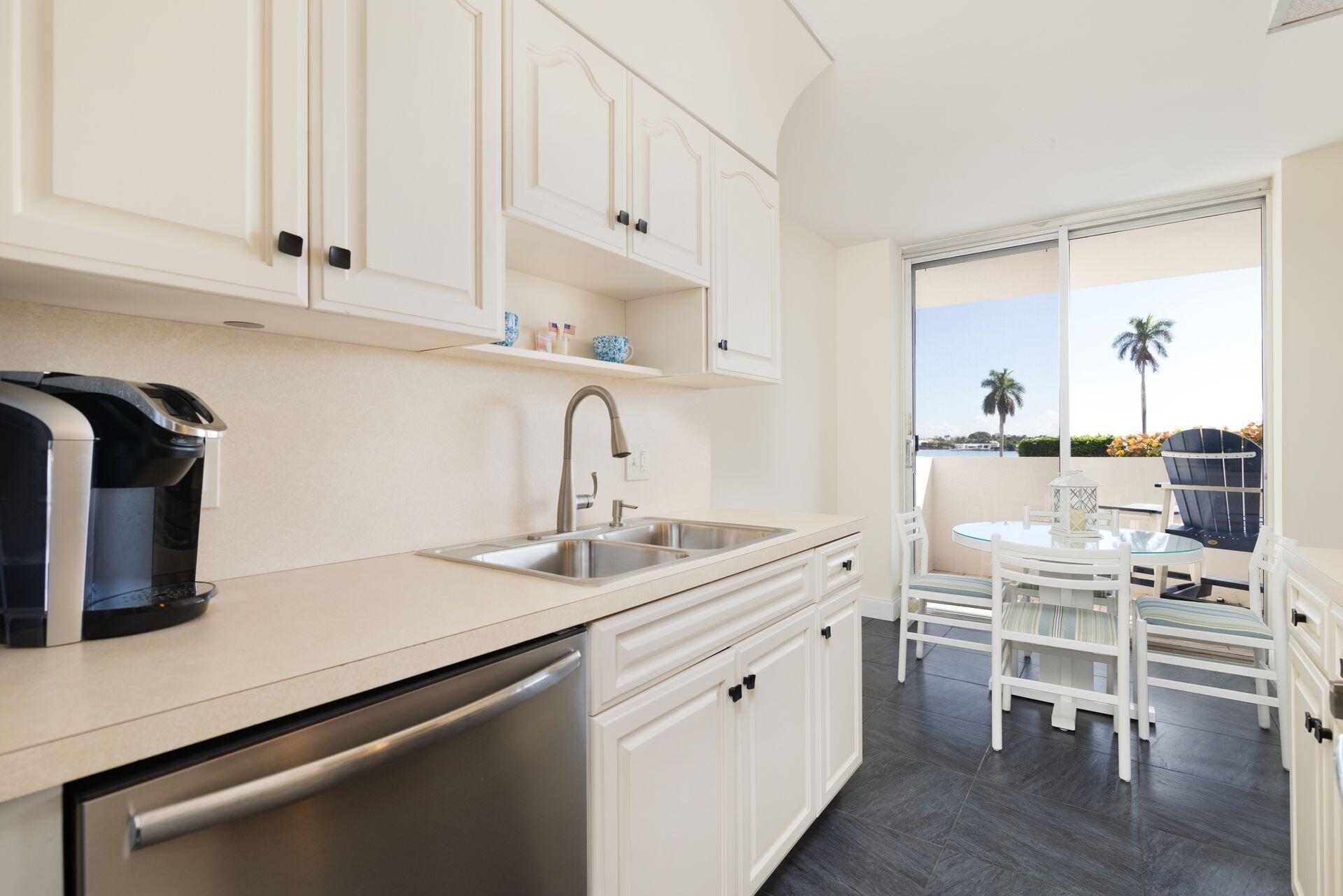 1701 South Flagler Drive, Unit 207 West Palm Beach, FL 33401 - Photo 9 of 26 a kitchen with a sink cabinets and wooden floor